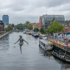 Bydgoszcz atrakcje na weekend: rzeźba "Przechodzący przez rzekę" na Brdzie, statki wycieczkowe i zabytkowa zabudowa.