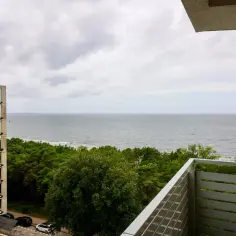 Widok na morze z budowy hotelu Slavia Międzyzdroje. Widać fragment budowanego obiektu, las i plażę.