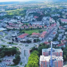 Widok z lotu ptaka na miasto z drogami, budynkami mieszkalnymi i handlowymi. Zastanawiasz się, ile mieszkańców ma Kołobrzeg?