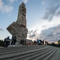 Uroczystość na Westerplatte. Zwiedzanie pomnika i składanie wieńców. W tle chmury i drzewa.