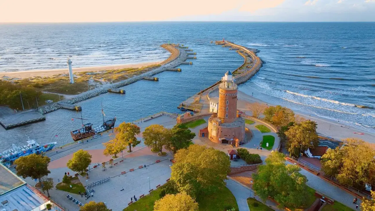Port z latarnią morską, statkiem pirackim i plażą. Idealne miejsce, gdzie na wakacje nad polskim morzem.