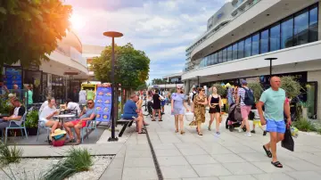 Spacer po tętniącym życiem świnoujście stare miasto. Ludzie spacerują, siedzą w kawiarniach, ciesząc się słońcem i wakacyjną atmosferą.