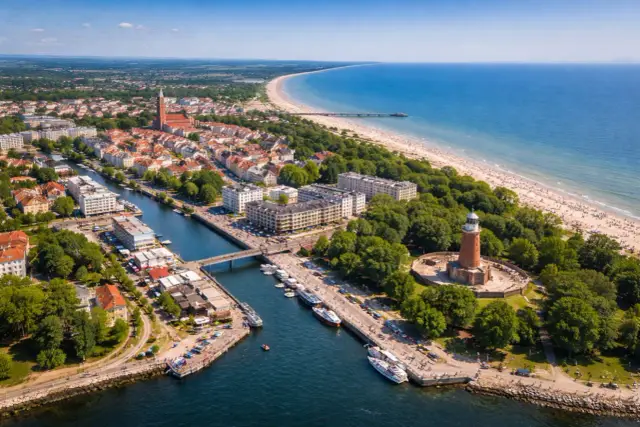 Widok na port, plażę i latarnię morską w Kołobrzegu. Miasto z bogatą historią, gdzie nowoczesność spotyka się z nadmorskim klimatem.