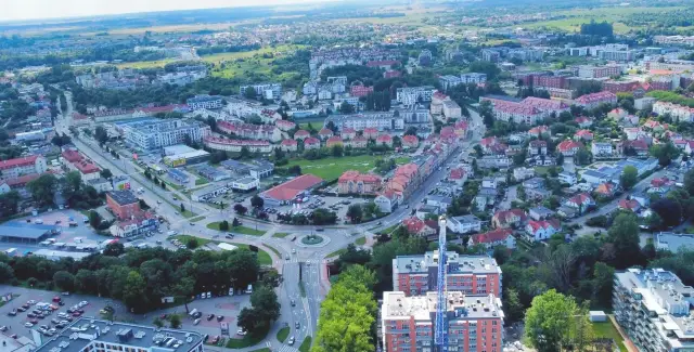 Widok z lotu ptaka na miasto z drogami, budynkami mieszkalnymi i handlowymi. Zastanawiasz się, ile mieszkańców ma Kołobrzeg?